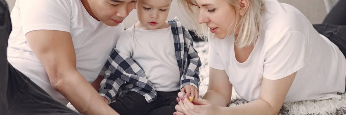 Loving family creating art together, fostering play and connection indoors.